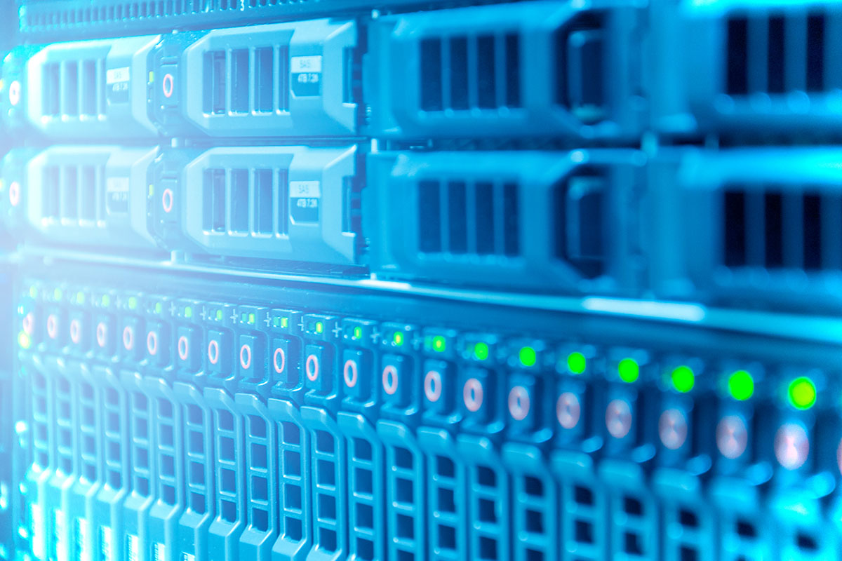Close-up of hot-swap drive bays in an enterprise storage array, lit blue with green status lights along the lower row
