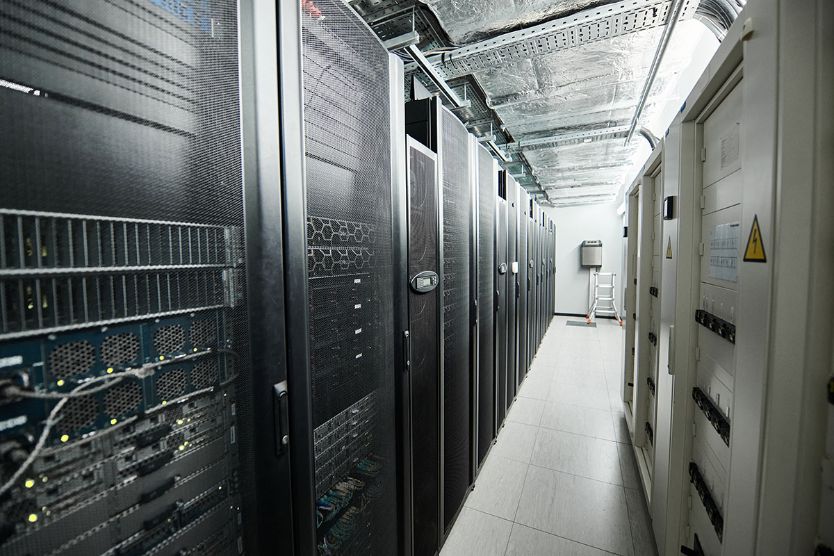 An aisle of server racks and structured cabling inside a data centre